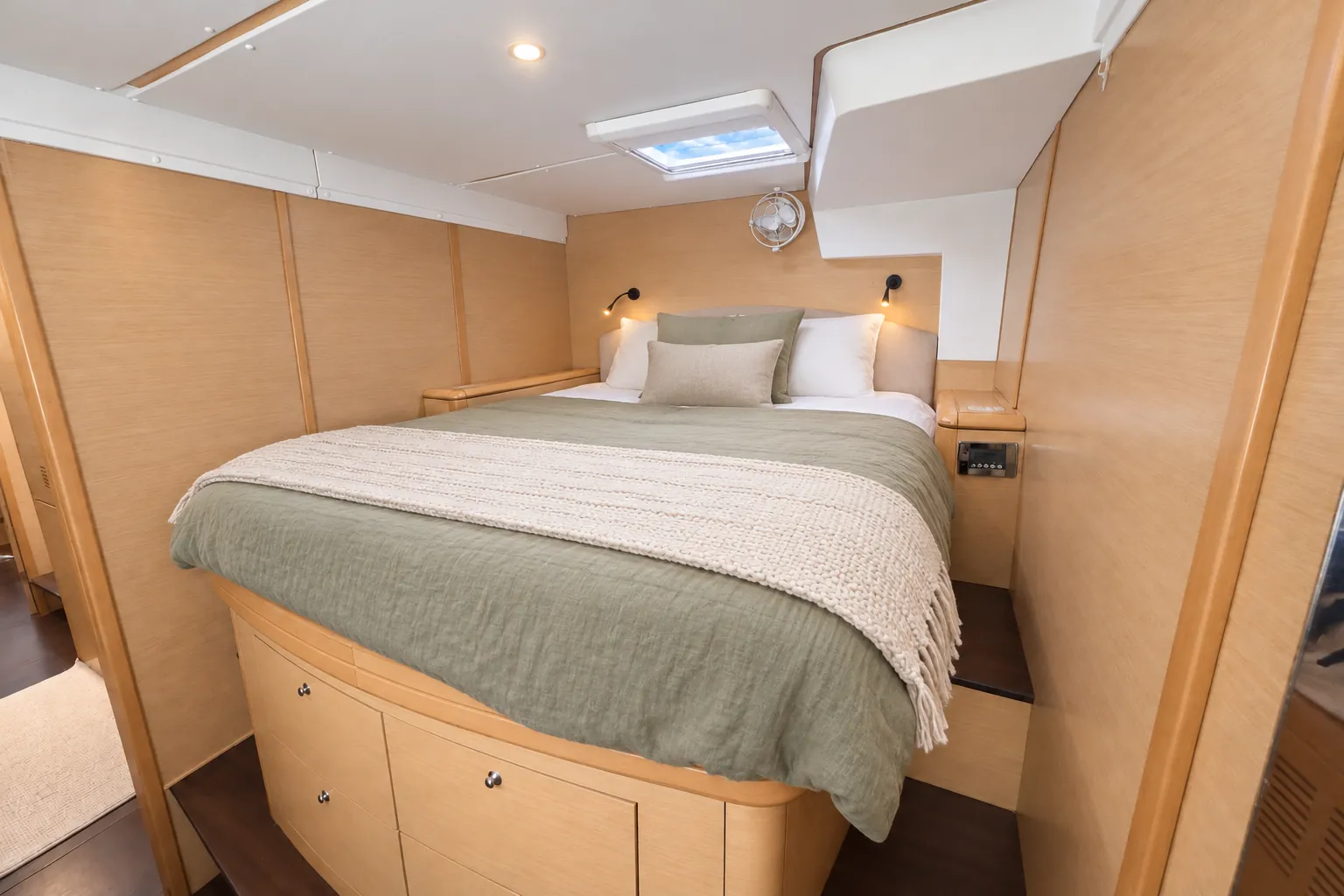 Lagoon 500 cabin with a sage linen bedspread and overhead hatch